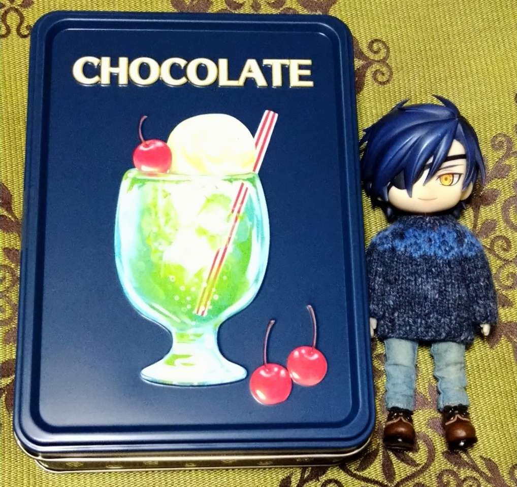 Mitsu lângă o cutie de bomboane de ciocolată jigsaw puzzle online