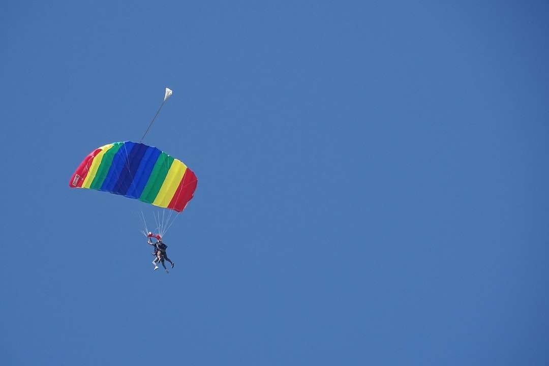 osoba na padáku pod modrou oblohou během dne skládačky online
