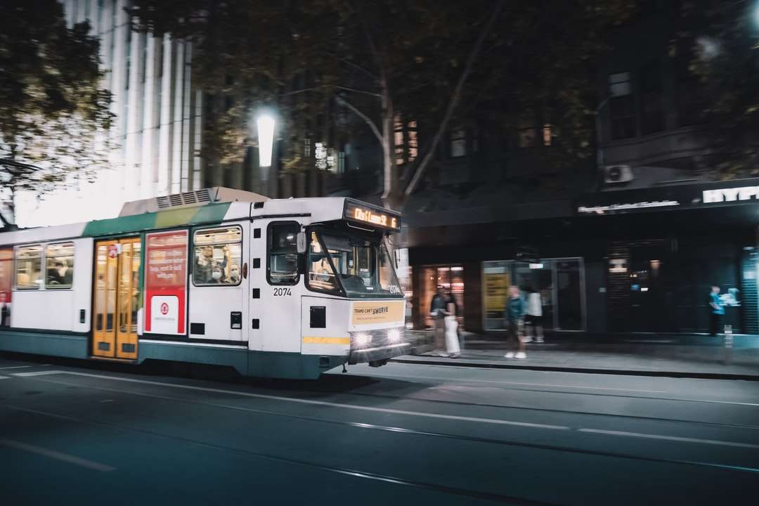 vit och grön spårvagn på väg under natten Pussel online