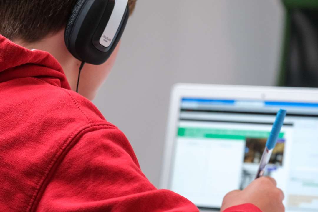 Person im roten Hemd, das schwarze und graue Kopfhörer trägt Online-Puzzle