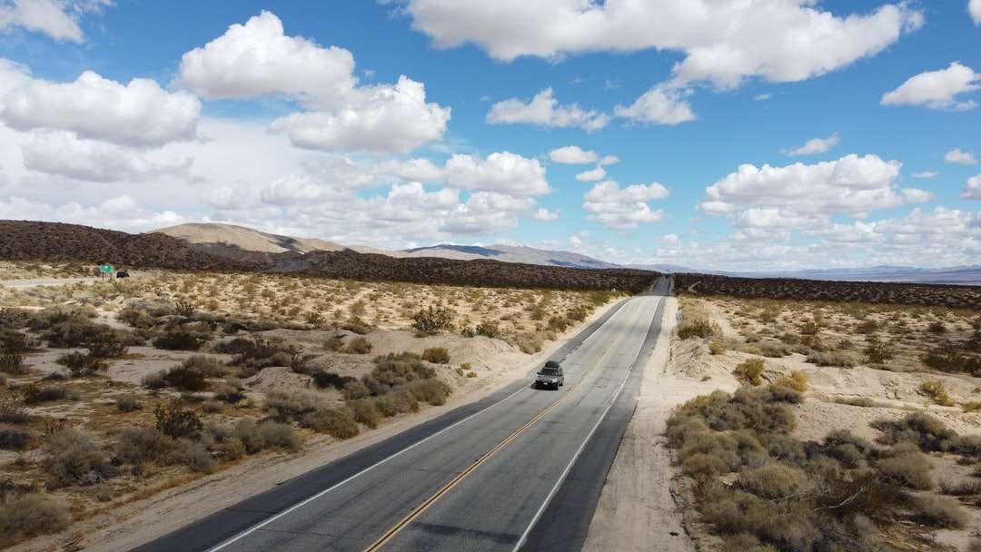 Carretera de asfalto gris bajo un cielo azul durante el día rompecabezas en línea