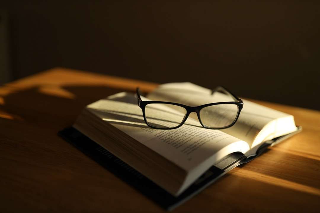 occhiali con montatura nera sulla pagina del libro puzzle online
