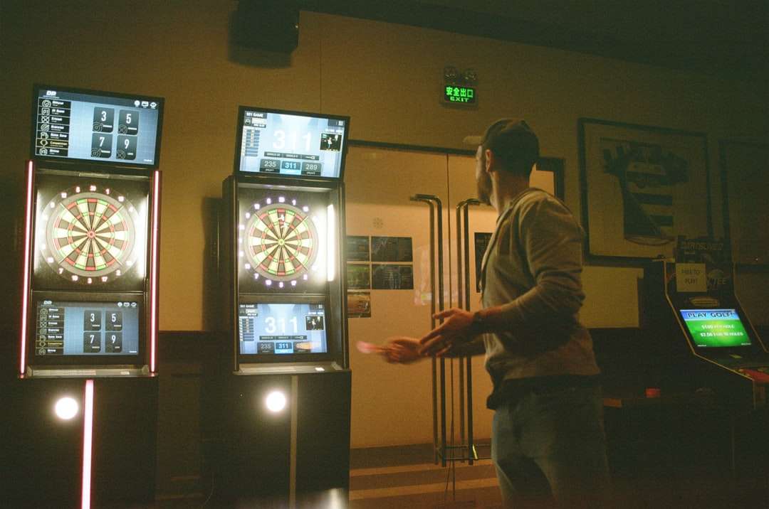 uomo in giacca marrone in piedi vicino alla tv a schermo piatto nero puzzle online