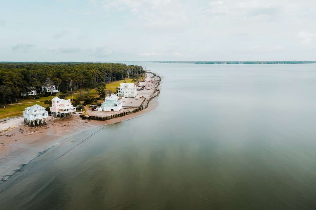 casă albă și maro pe insulă înconjurată de corp de apă puzzle online