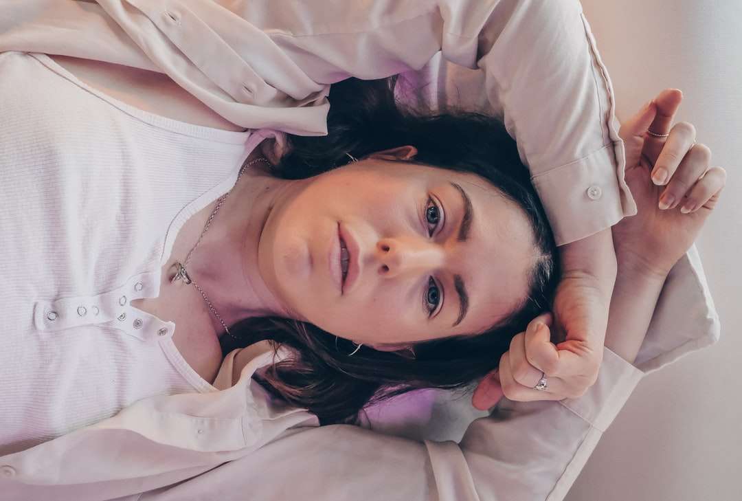dívka v bílé košili s dlouhým rukávem, ležící na posteli online puzzle