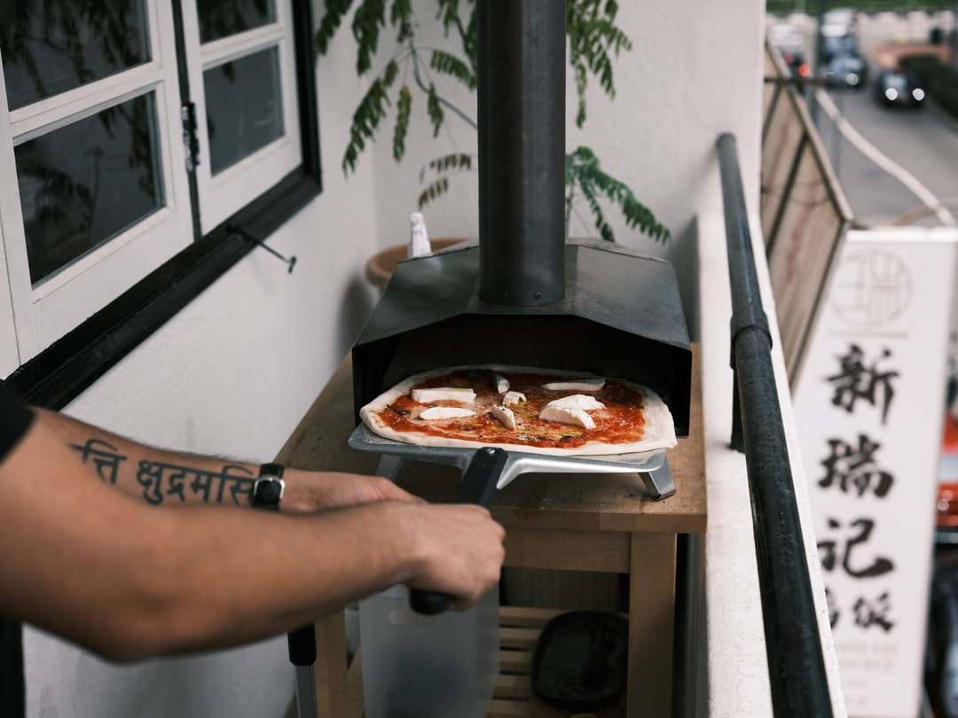 човек, който държи чиния с пица онлайн пъзел