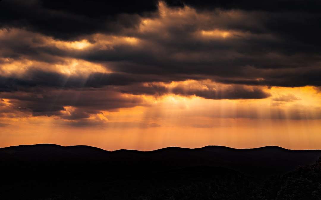 silhueta da montanha durante o pôr do sol puzzle online
