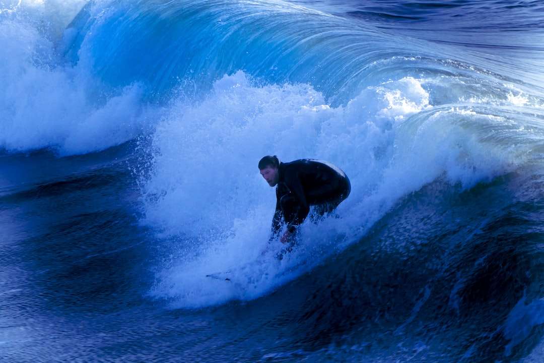 мужчина в черном гидрокостюме занимается серфингом на голубых океанских волнах пазл онлайн