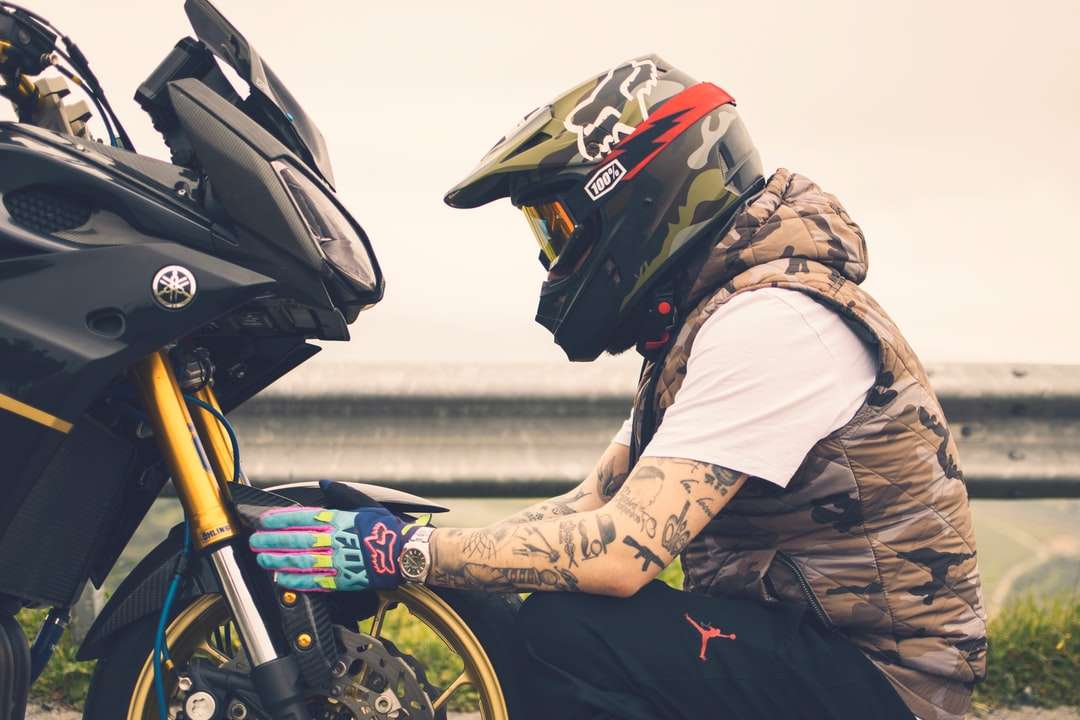 om în jachetă maro și cască neagră călare pe motocicletă jigsaw puzzle online