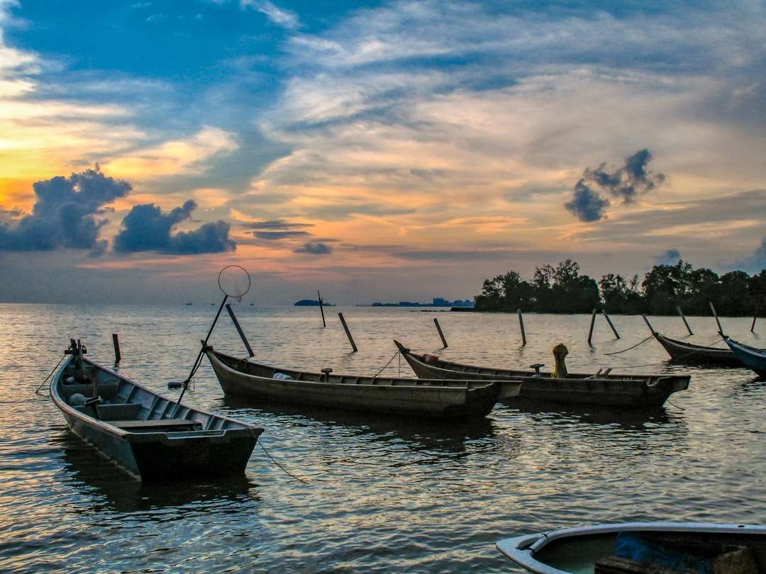Boot auf dem Wasser während des Sonnenuntergangs Online-Puzzle