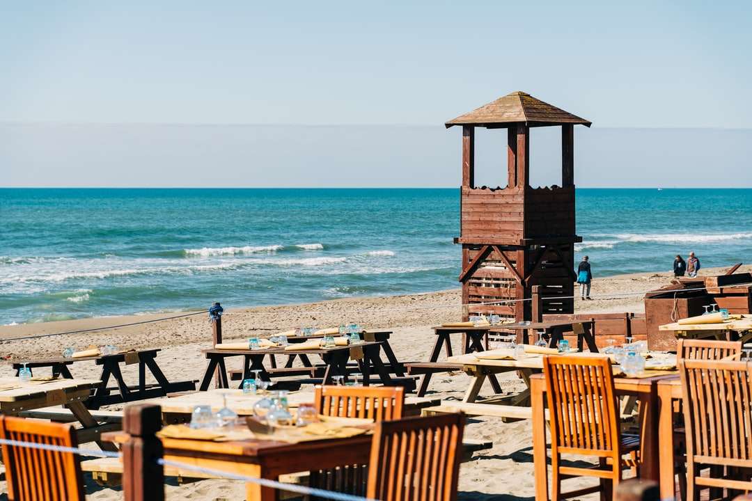 brunt träräddare torn på stranden under dagtid pussel på nätet