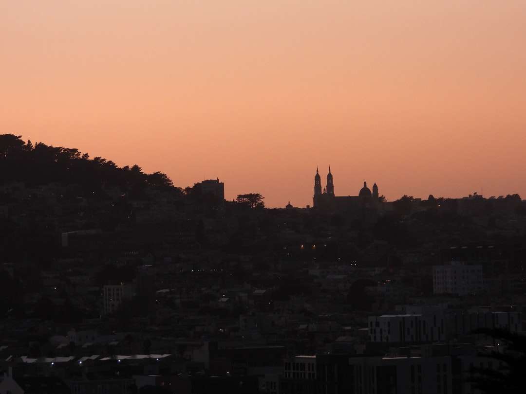 silhuett av stadsbyggnader under solnedgången Pussel online