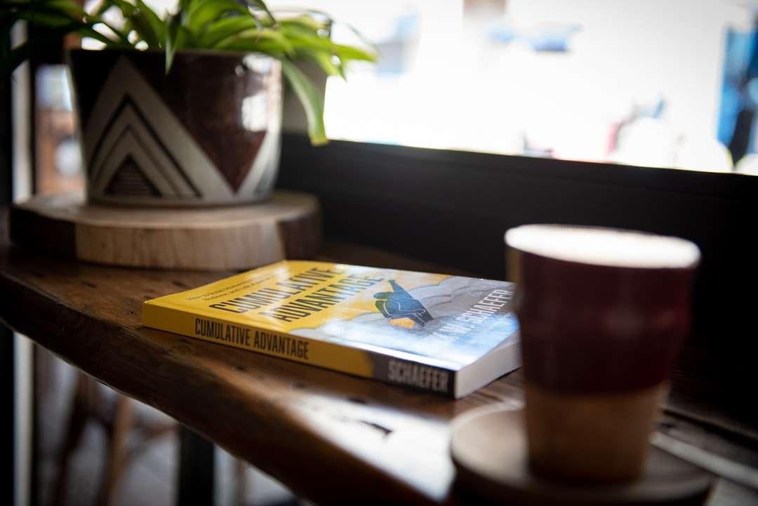 Μπλε και κίτρινο βιβλίο δίπλα σε καφέ κεραμική κούπα online παζλ