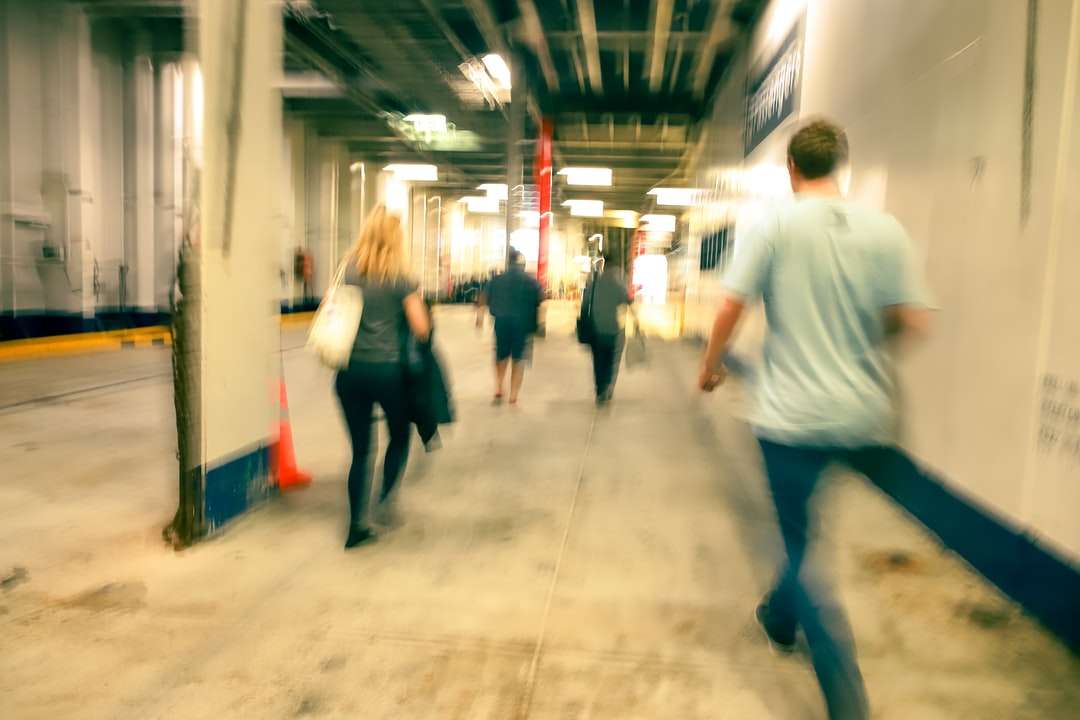 man in white t-shirt and blue denim jeans walking on hallway online puzzle
