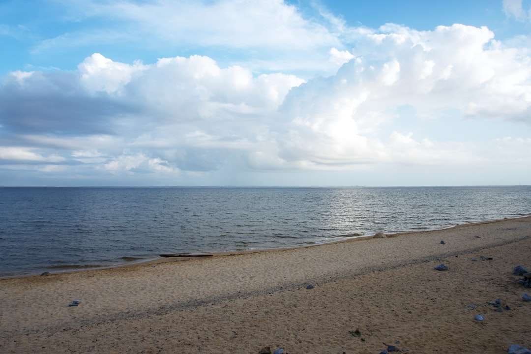 кафяв пясък близо до вода под бели облаци онлайн пъзел