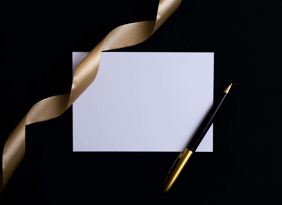Černé a zlaté pero na bílém papíře online puzzle