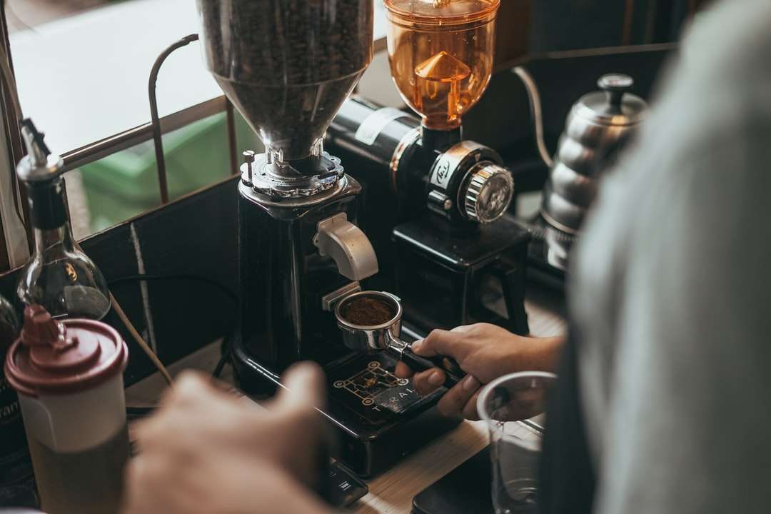 Persoana care toarnă cafea pe cana de sticlă clară puzzle online