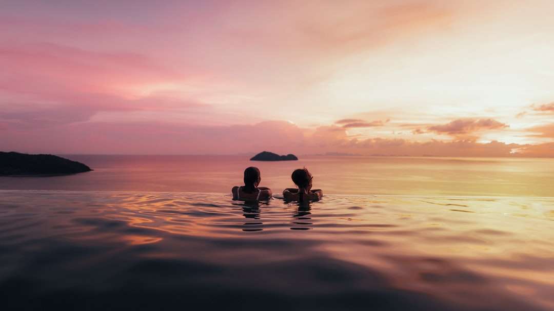 Silhouette von 2 Personen auf Körper des Wassers während des Sonnenuntergangs Puzzlespiel online