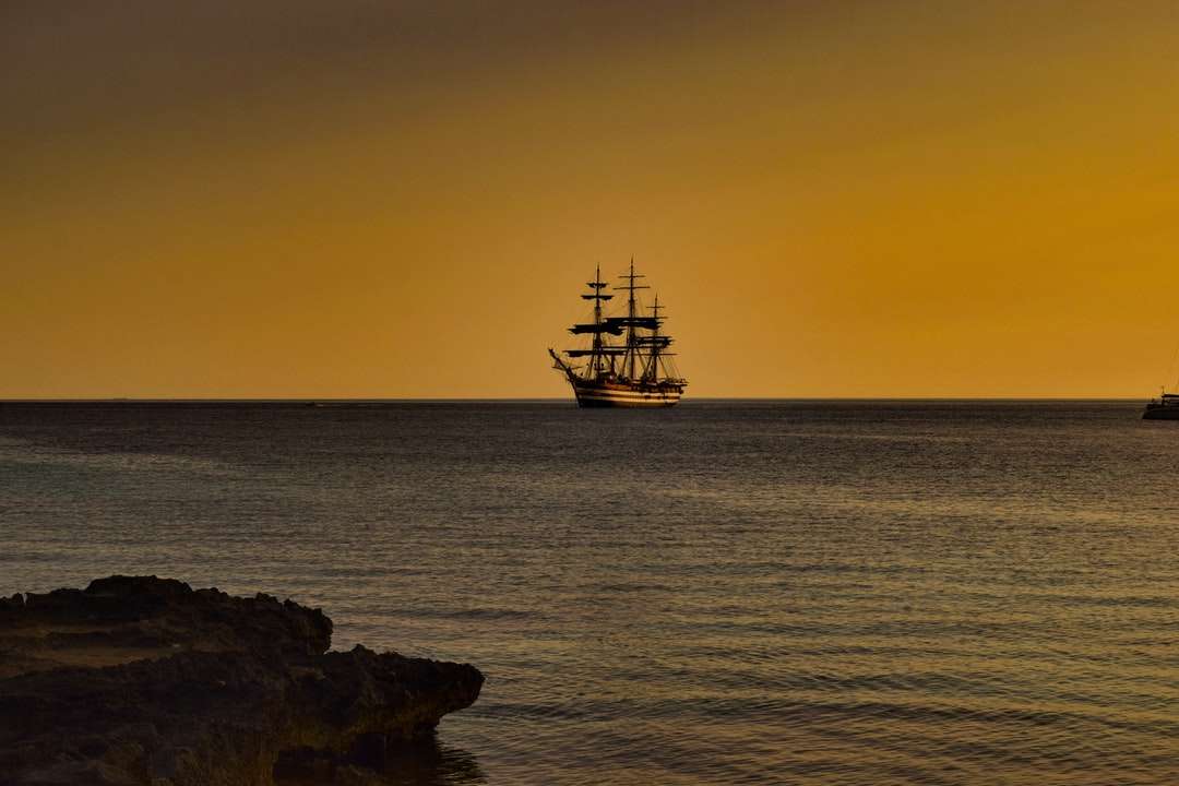 loď na moři při západu slunce skládačky online