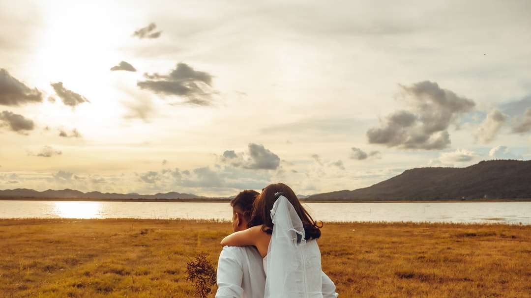 Couple s'embrassant sur le champ d'herbe verte pendant la journée puzzle en ligne