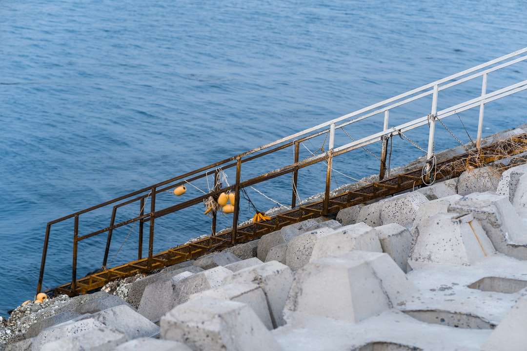 коричневий дерев'яний док на синьому морі в денний час пазл онлайн