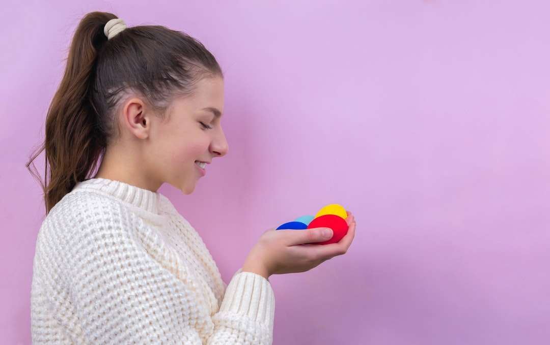 Vrouw in witte gebreide trui die blauwe bal houdt legpuzzel online