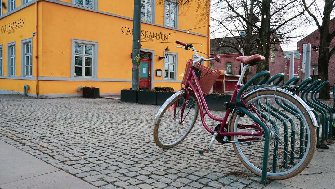 Vörös városi kerékpár parkolt barna beton épület mellett online puzzle