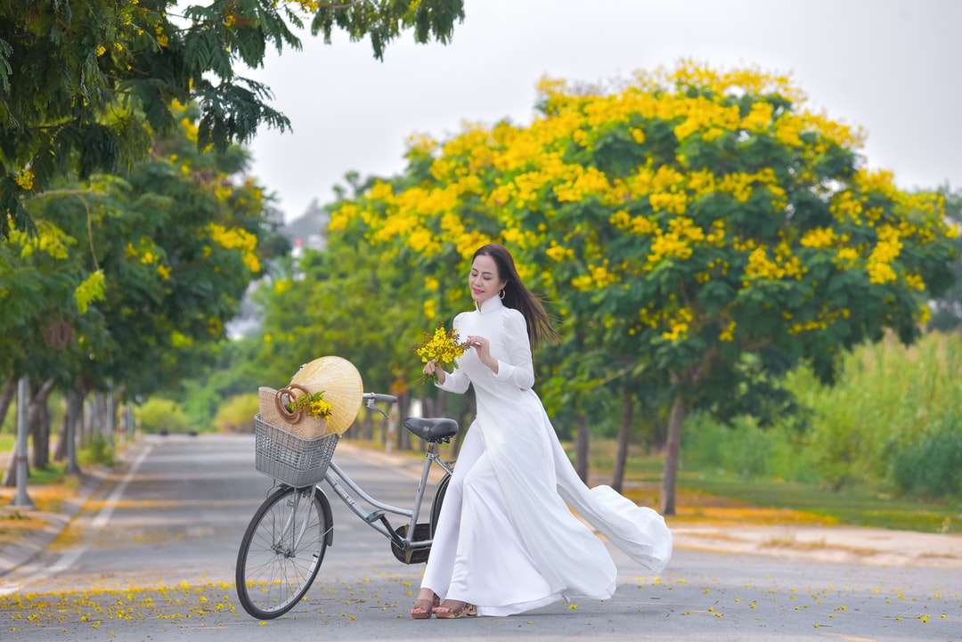 Жена в бяла рокля, държейки жълт цвете букет онлайн пъзел