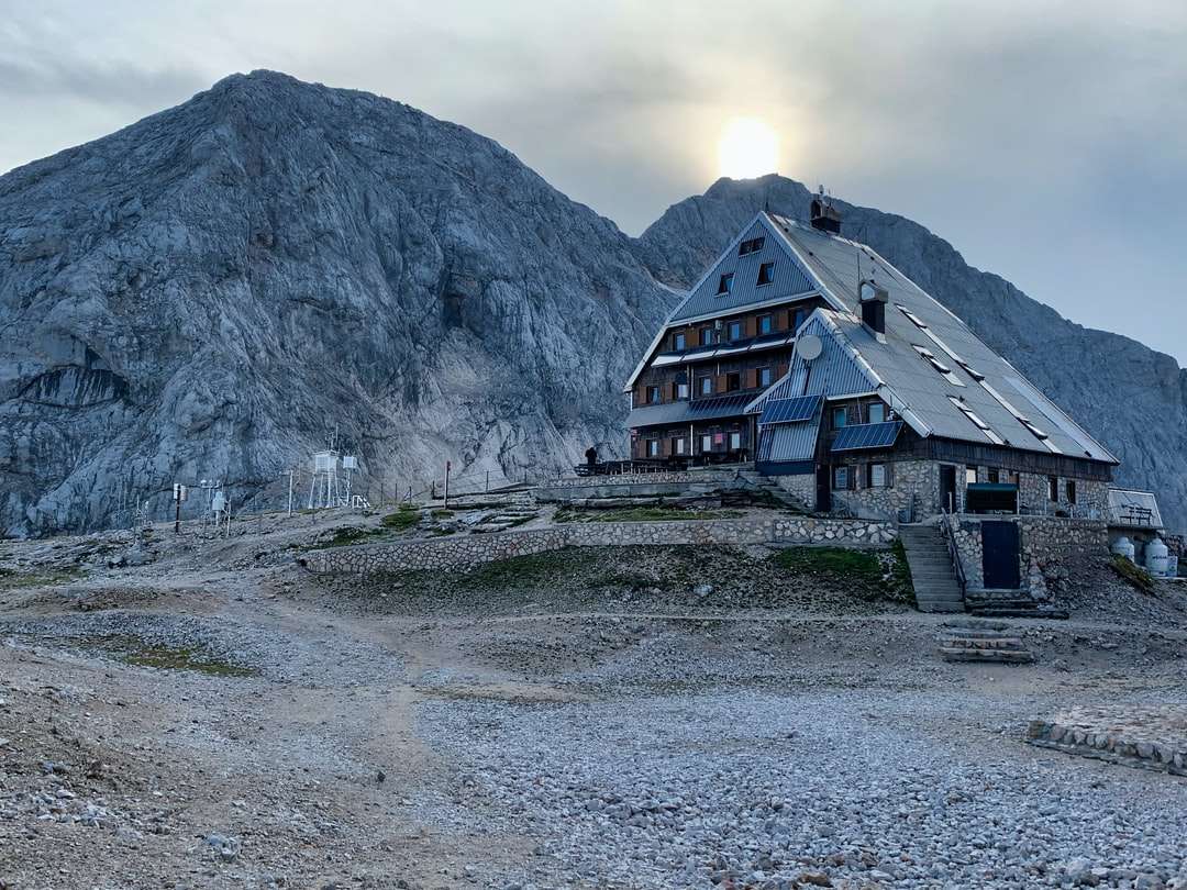Hnědý dřevěný dům poblíž hory během dne skládačky online
