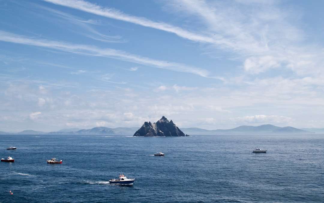 Бяла и синя лодка по море под синьо небе през деня онлайн пъзел