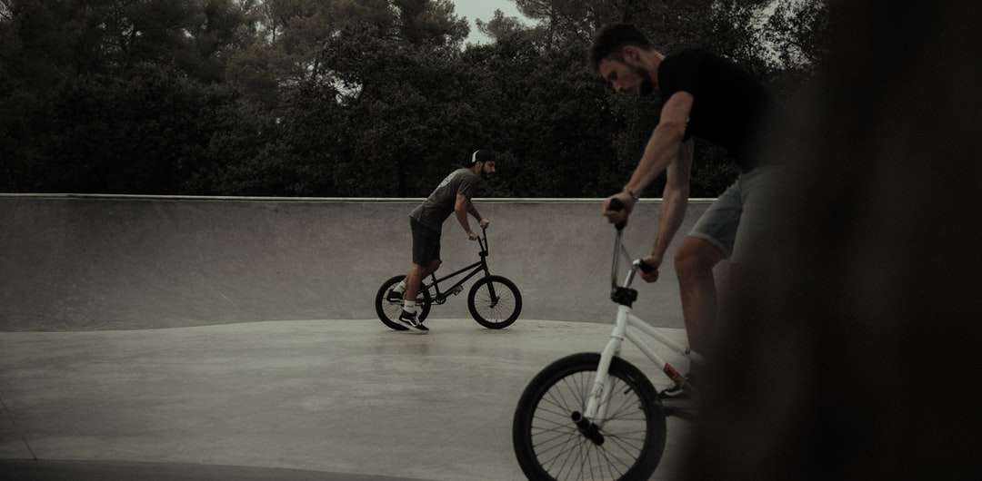 Hombre en camiseta sin mangas negra en bicicleta BMX blanca rompecabezas en línea