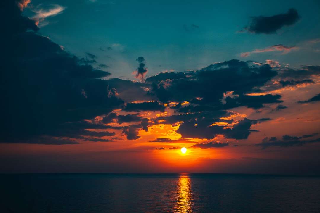 Silhouette de personne sur le plan d'eau au coucher du soleil puzzle en ligne