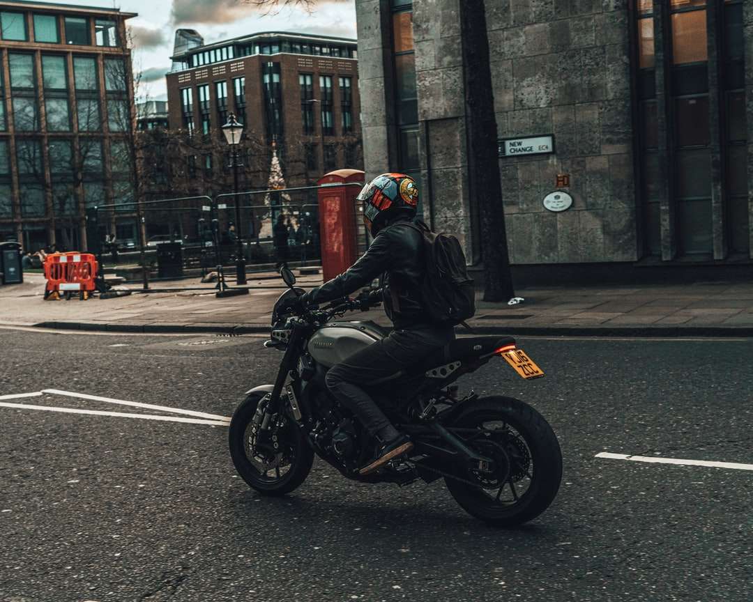 Homme en casque de moto noir équitation moto sur route puzzle en ligne
