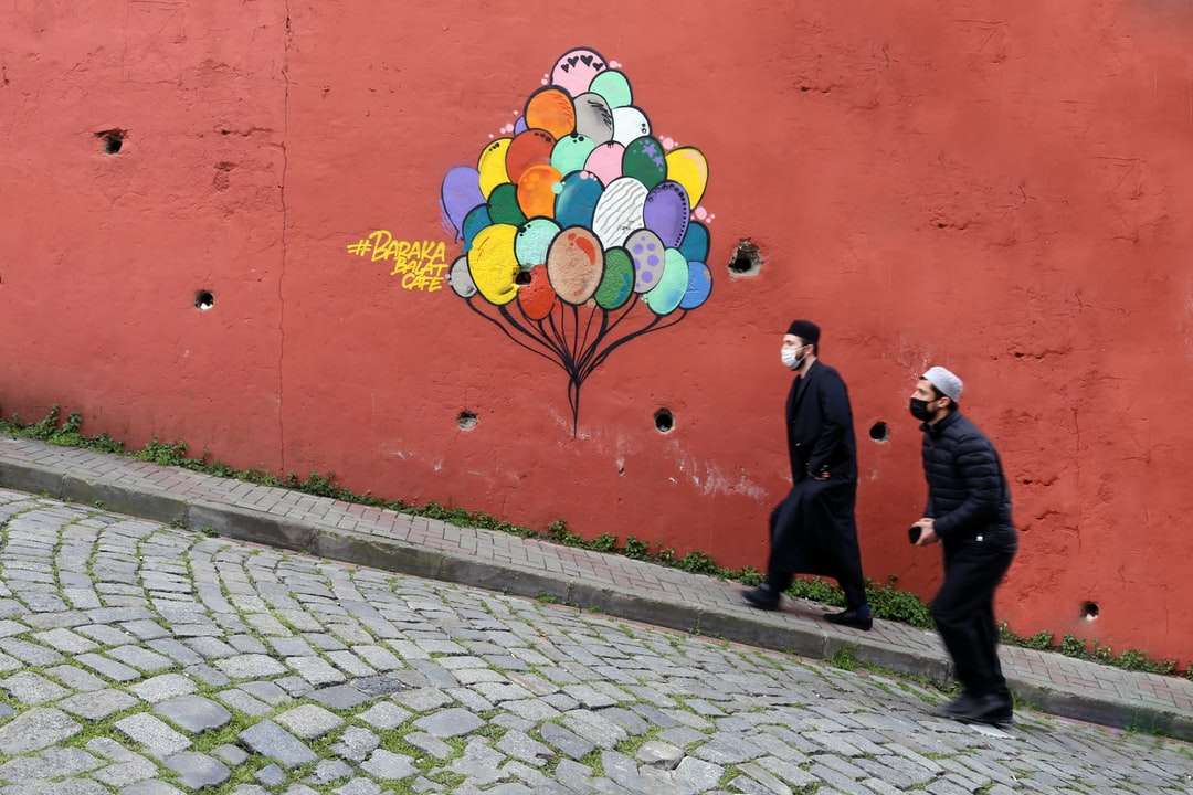 emberek sétálnak a járdán piros fal közelében kirakós online