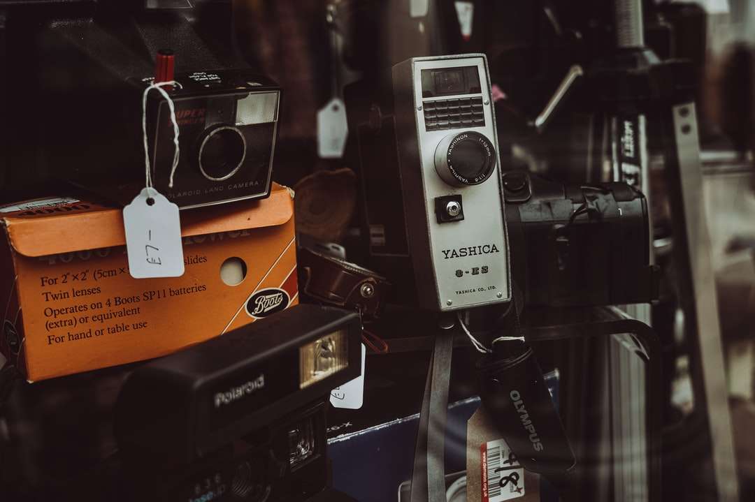 Svart och silver kamera på orange låda Pussel online