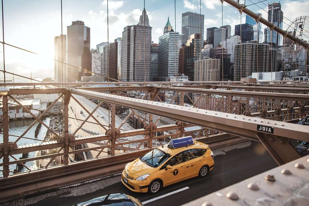 Žlutá taxi kabina na mostě během dne online puzzle