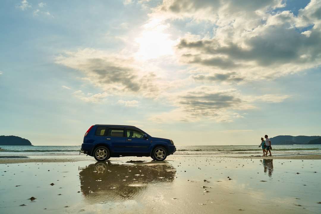 Blue SUV na pláži během dne skládačky online