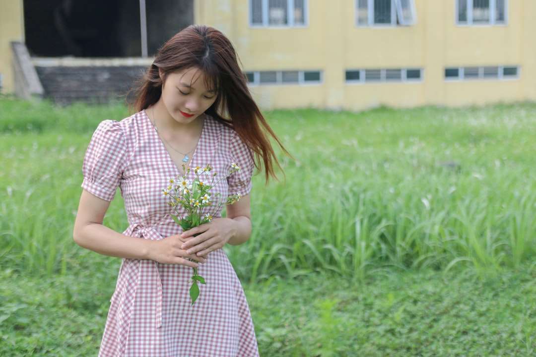 Mujer en vestido blanco y rojo de pie en campo de hierba verde rompecabezas en línea