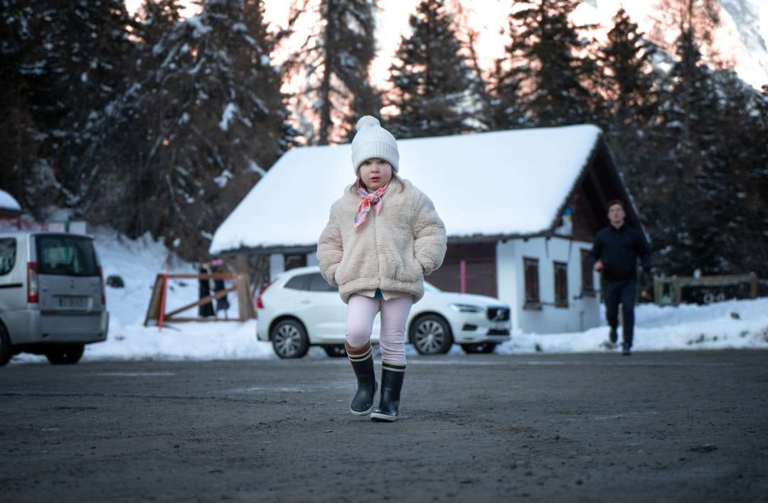 Femeie în haina maro în picioare pe terenul acoperit de zăpadă puzzle online