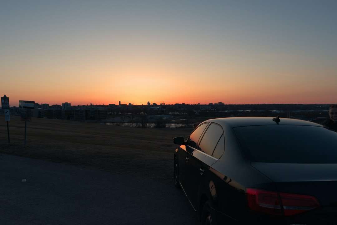 Sedan noire sur la route pendant le coucher du soleil puzzle en ligne