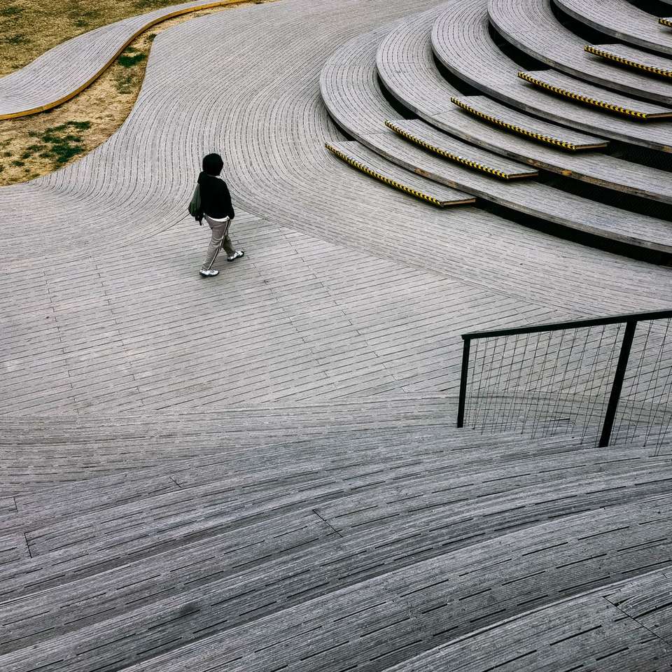 Homme en veste noire marchant sur une voie de béton grise puzzle en ligne