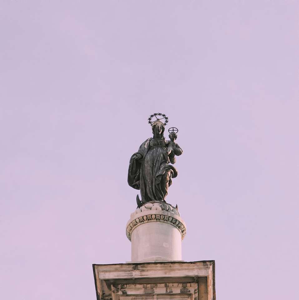 Estatua negra del hombre en la parte superior del edificio rompecabezas en línea