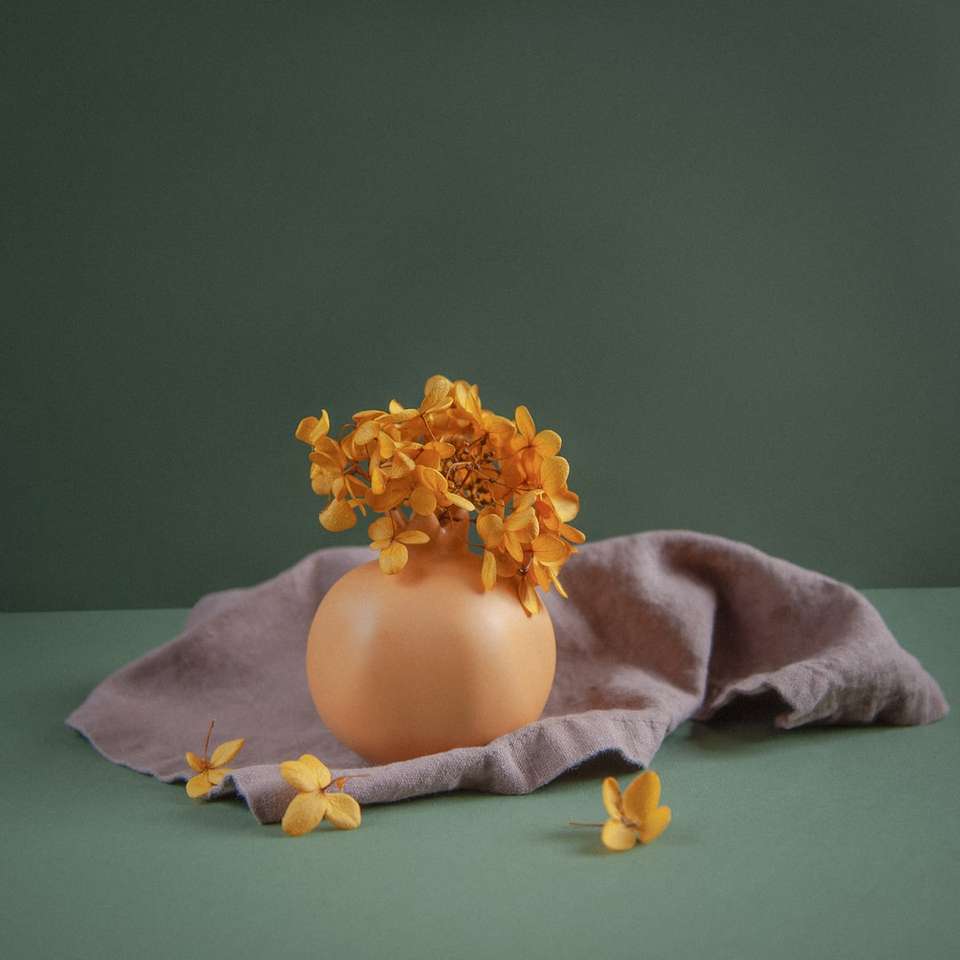 желтый цветок на коричневой керамической вазе пазл онлайн