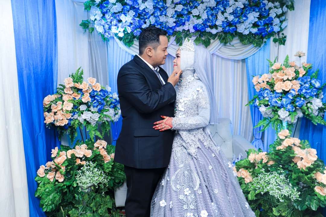 Homem de terno preto beijando a mulher no vestido de casamento branco puzzle online