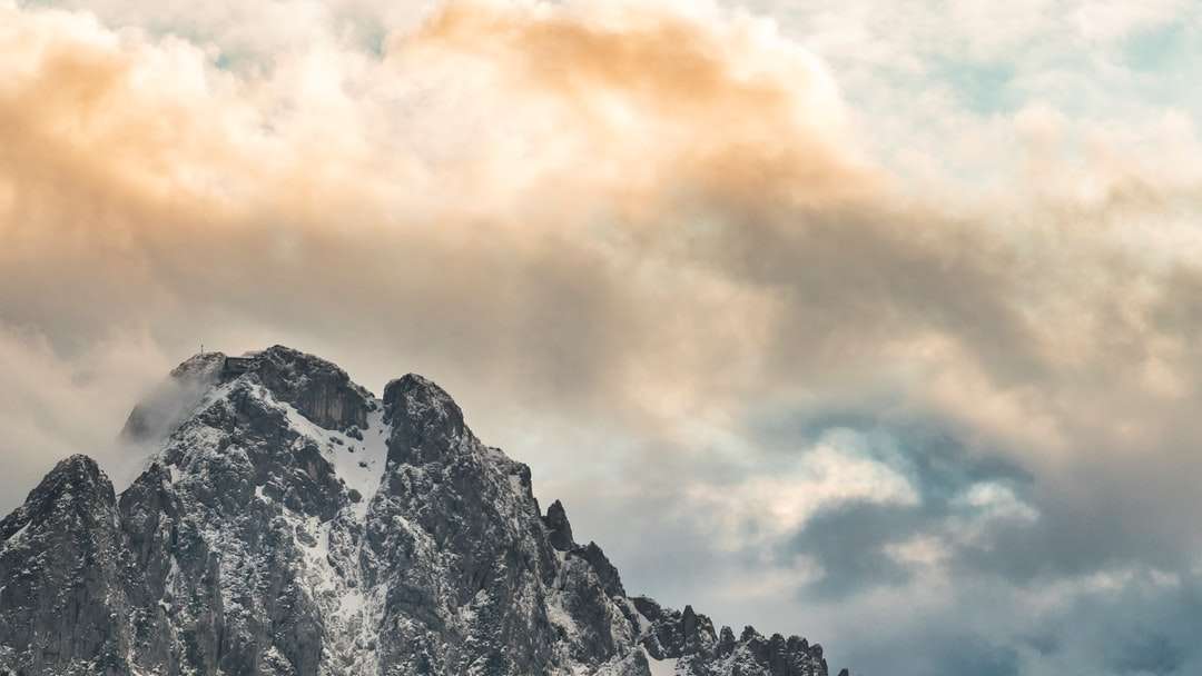 Montagna innevata sotto il cielo nuvoloso durante il giorno puzzle online
