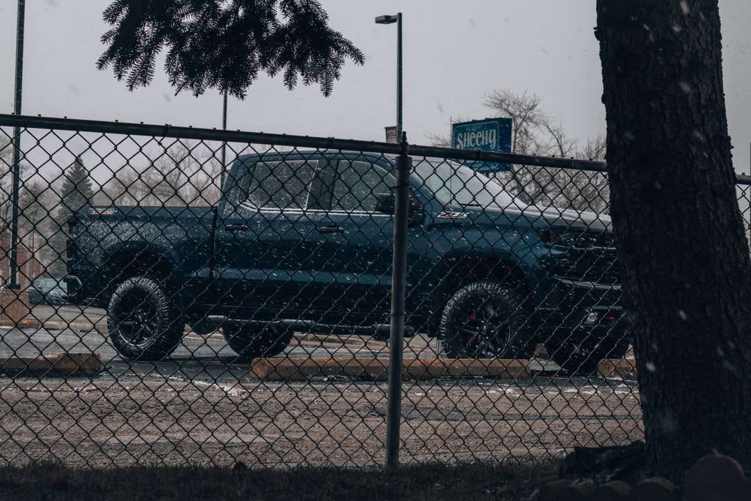 SUV negro estacionado ao lado da cerca de metal cinza durante o dia quebra-cabeças online