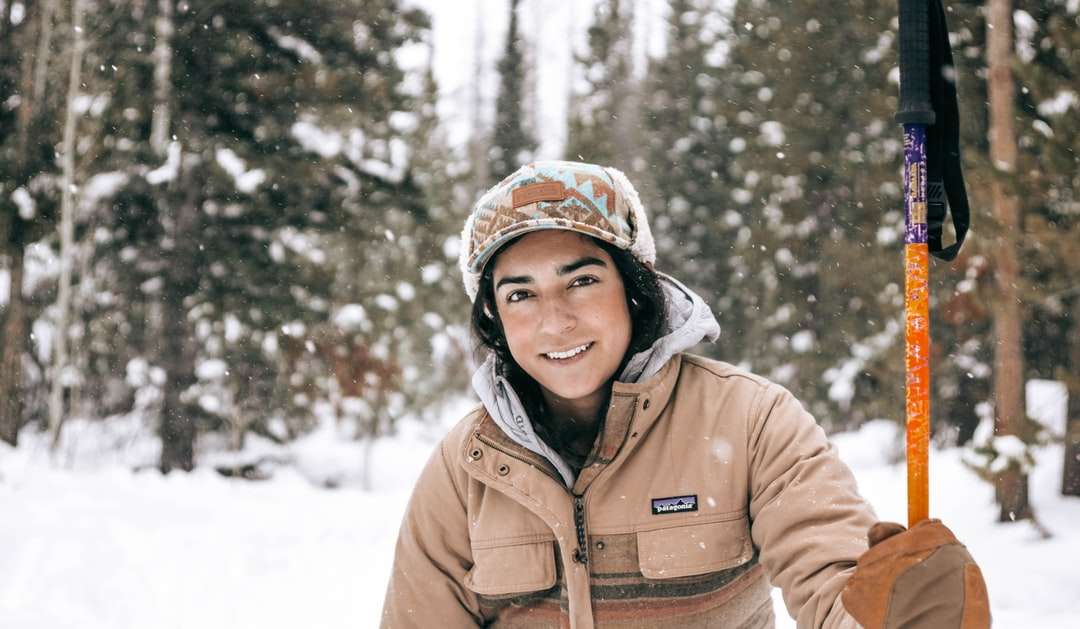 Γυναίκα σε καφέ σακάκι που στέκεται στο χιονισμένο έδαφος παζλ online