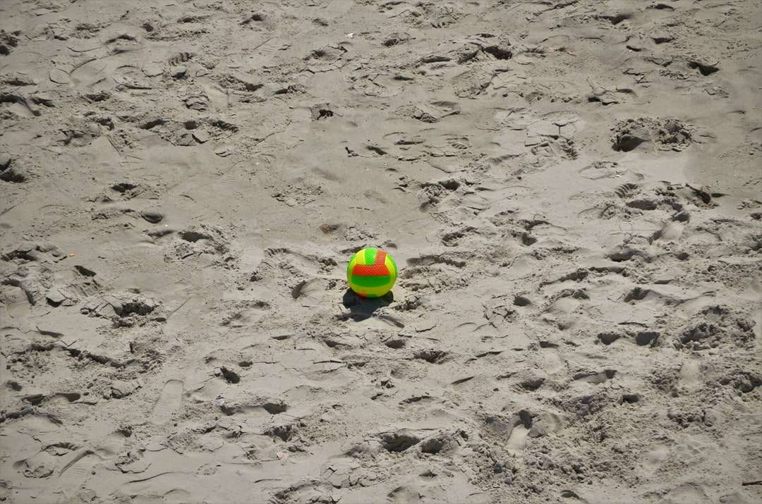 Grön och gul boll på vit sand Pussel online