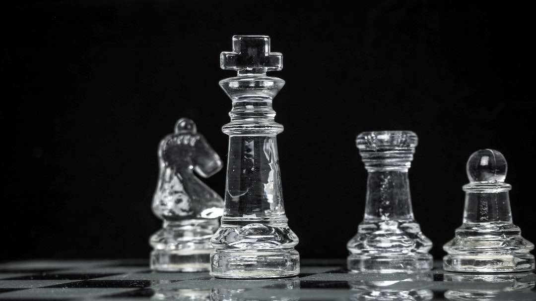 Pieza de ajedrez de cristal transparente en la mesa azul rompecabezas en línea
