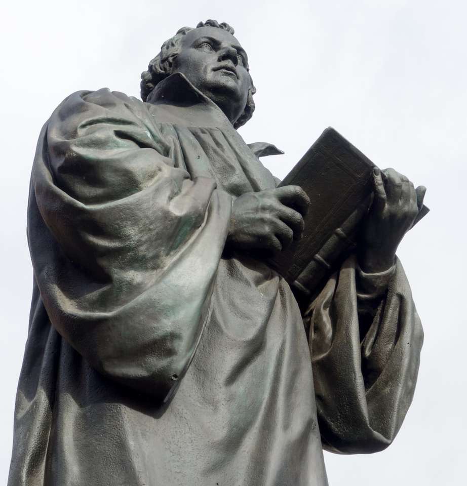 Muž v kabátě drží knihu socha skládačky online